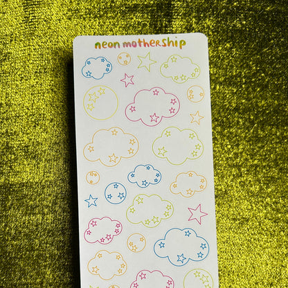 Sheet of colorful cloud and star stickers on a green textured background