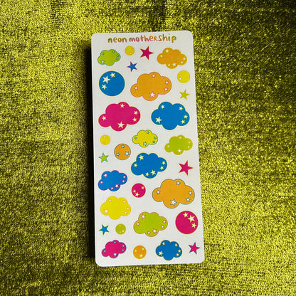 Sheet of colorful cloud and star stickers on a green textured background