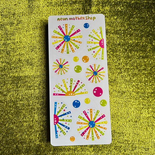 Sheet of colorful starburst stickers on a green textured background