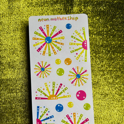 Colorful sticker sheet with starburst designs on a green textured background
