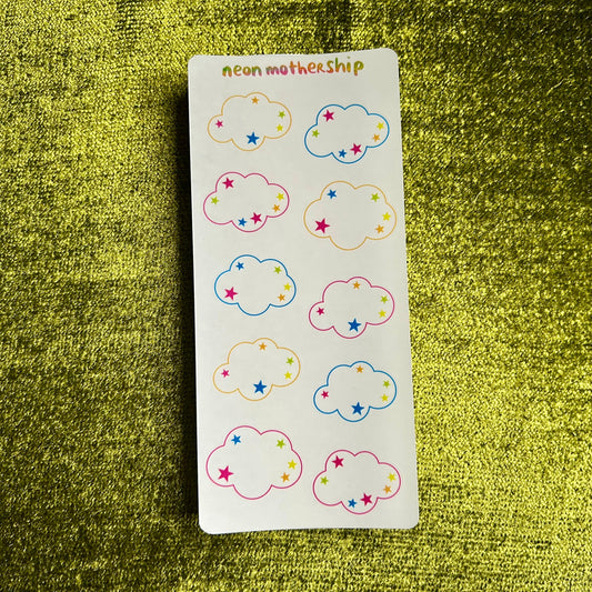 Sticker sheet of cloud-shaped stickers with colorful designs on a green textured surface