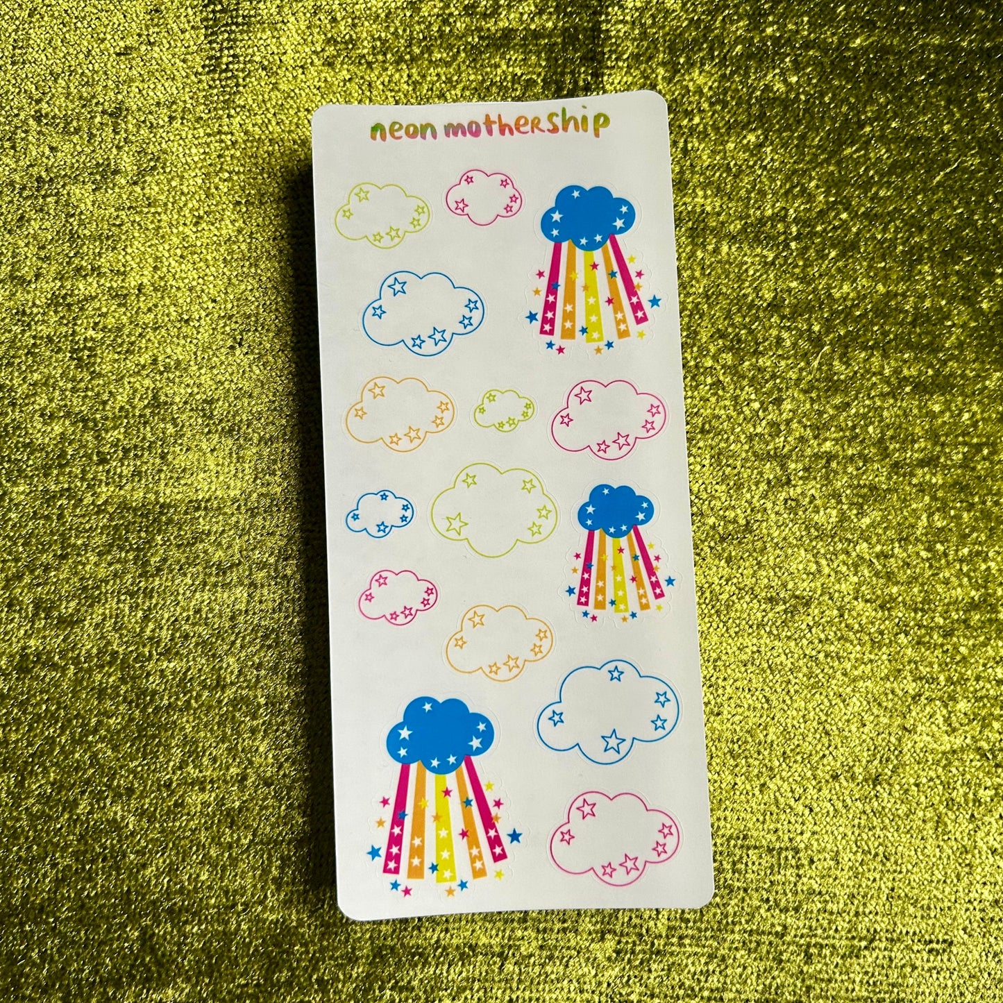 sticker sheet with paper cloud and star stickers on a green textured background