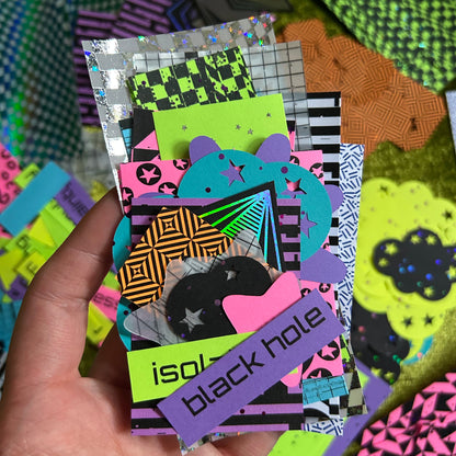 hand holding neon paper scraps with space and pop punk themed designs