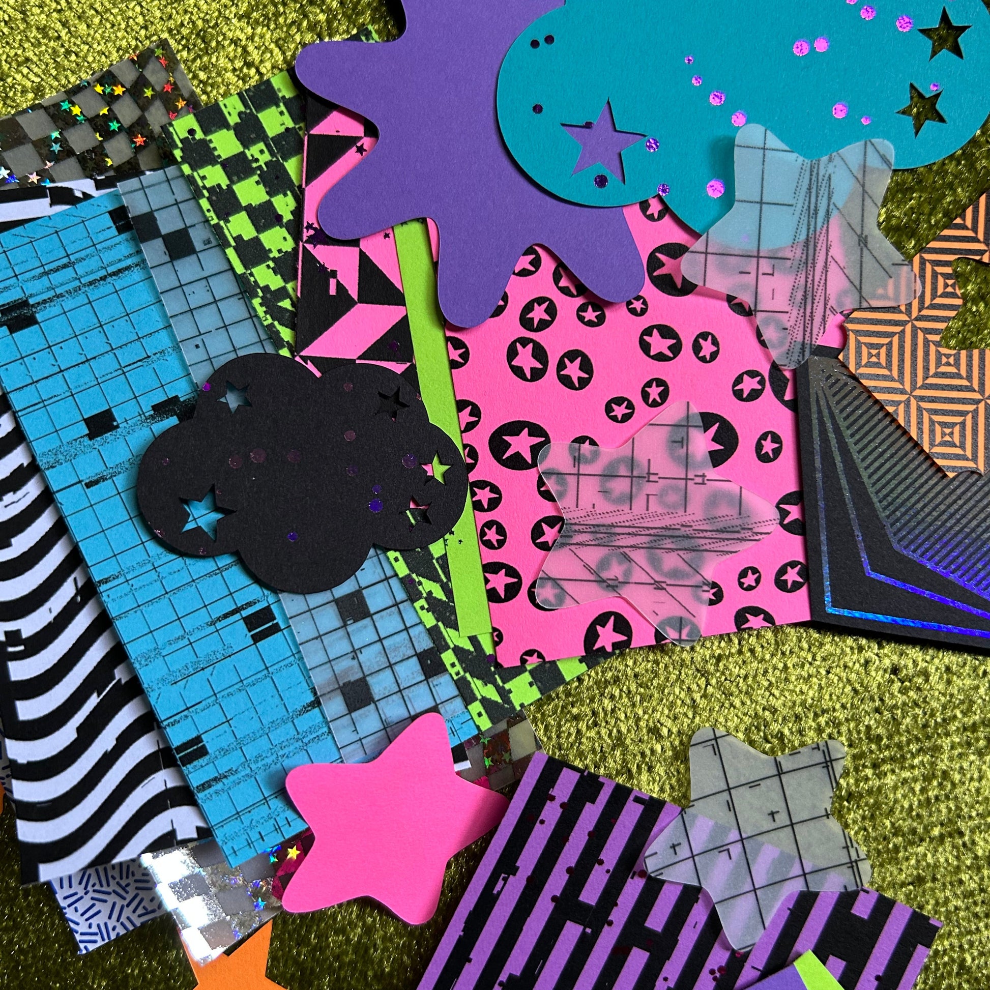 Collection of colorful geometric paper shapes on a textured surface
