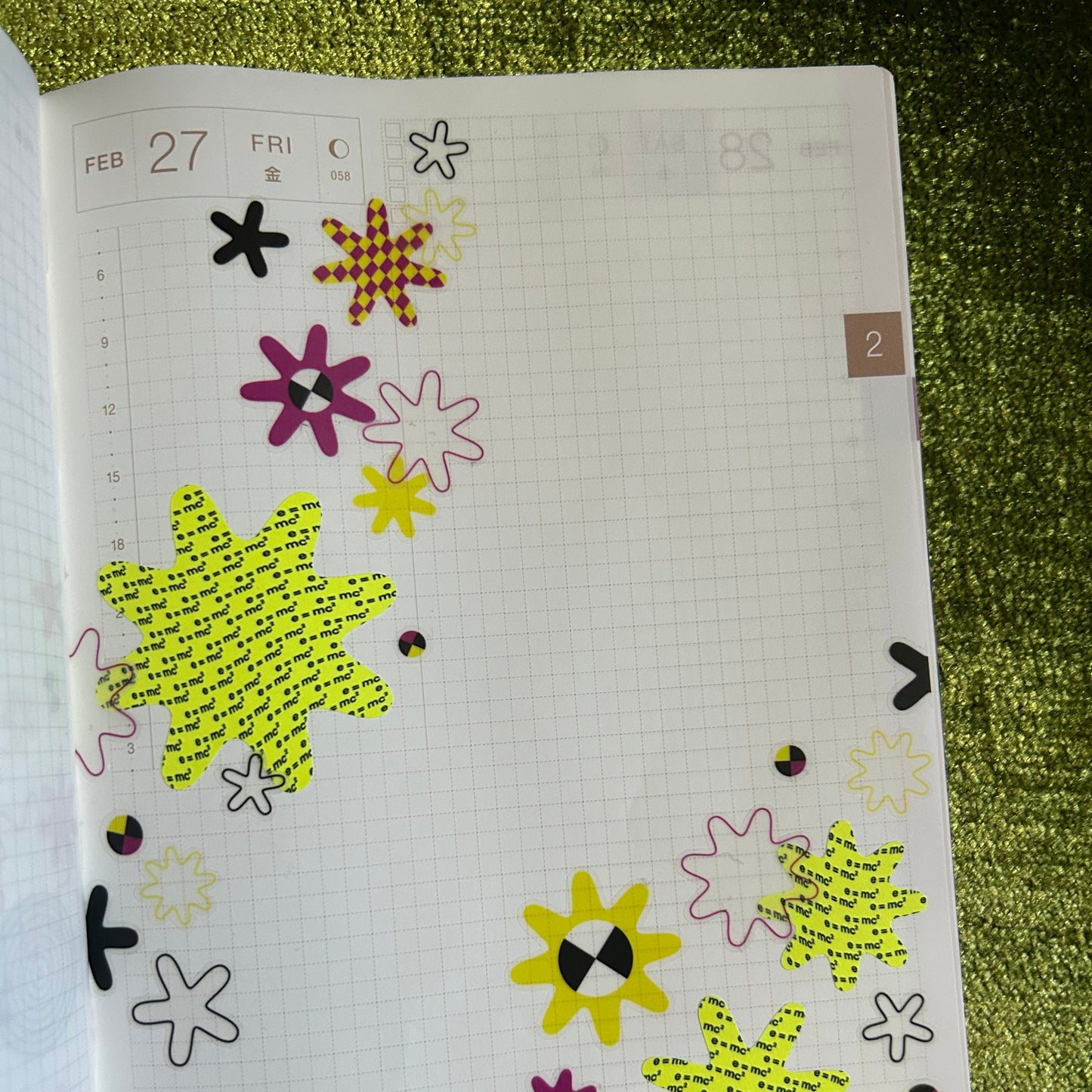 Sheet with decorative stickers on a textured green surface