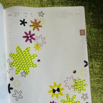 Sheet with decorative stickers on a textured green surface