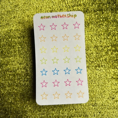 Sheet of star-shaped stickers with 'neon mothership' branding on a green textured background