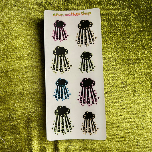 Sheet of cloud-shaped stickers with 'neon mothership' branding on a green textured background.