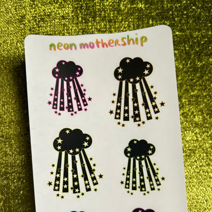 Sheet of cloud-shaped stickers with star details on a green glittery background, branded 'neon mothership'.