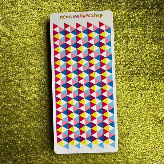 Colorful geometric patterned sticker sheet on a green textured surface
