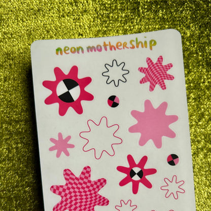 Sticker sheet with pink star-shaped stickers on a glittery green background
