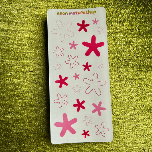 sticker sheet with pink and red star-shaped stickers on a green textured background
