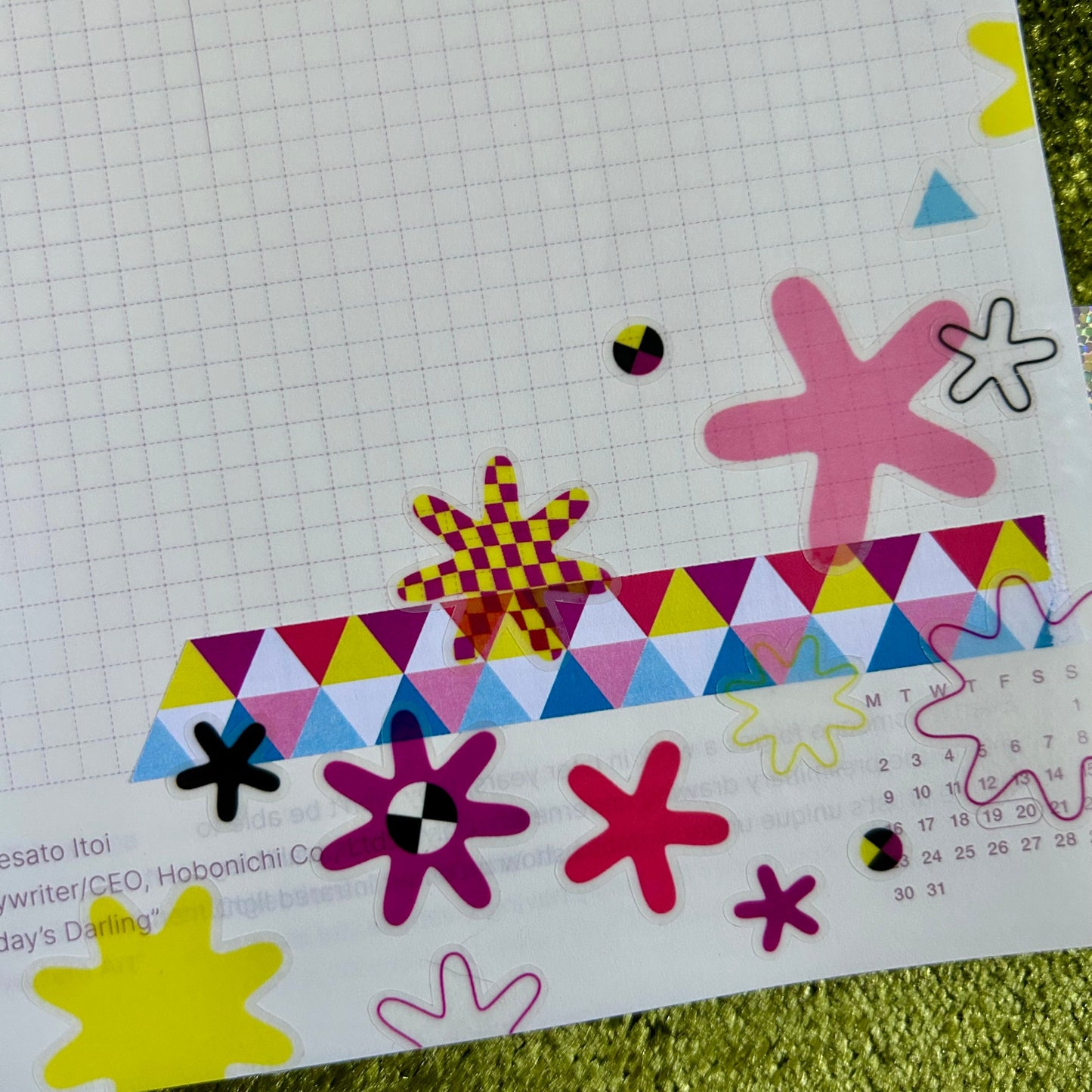 Colorful geometric and floral stickers on a grid notebook background