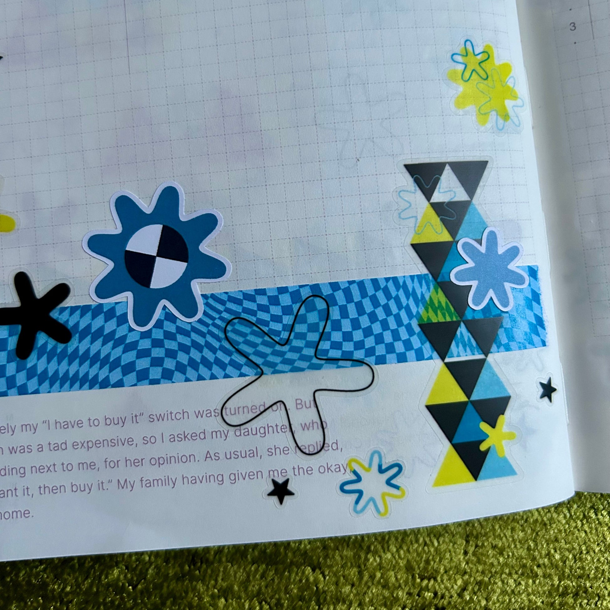Sheet of paper with colorful geometric designs on a green surface