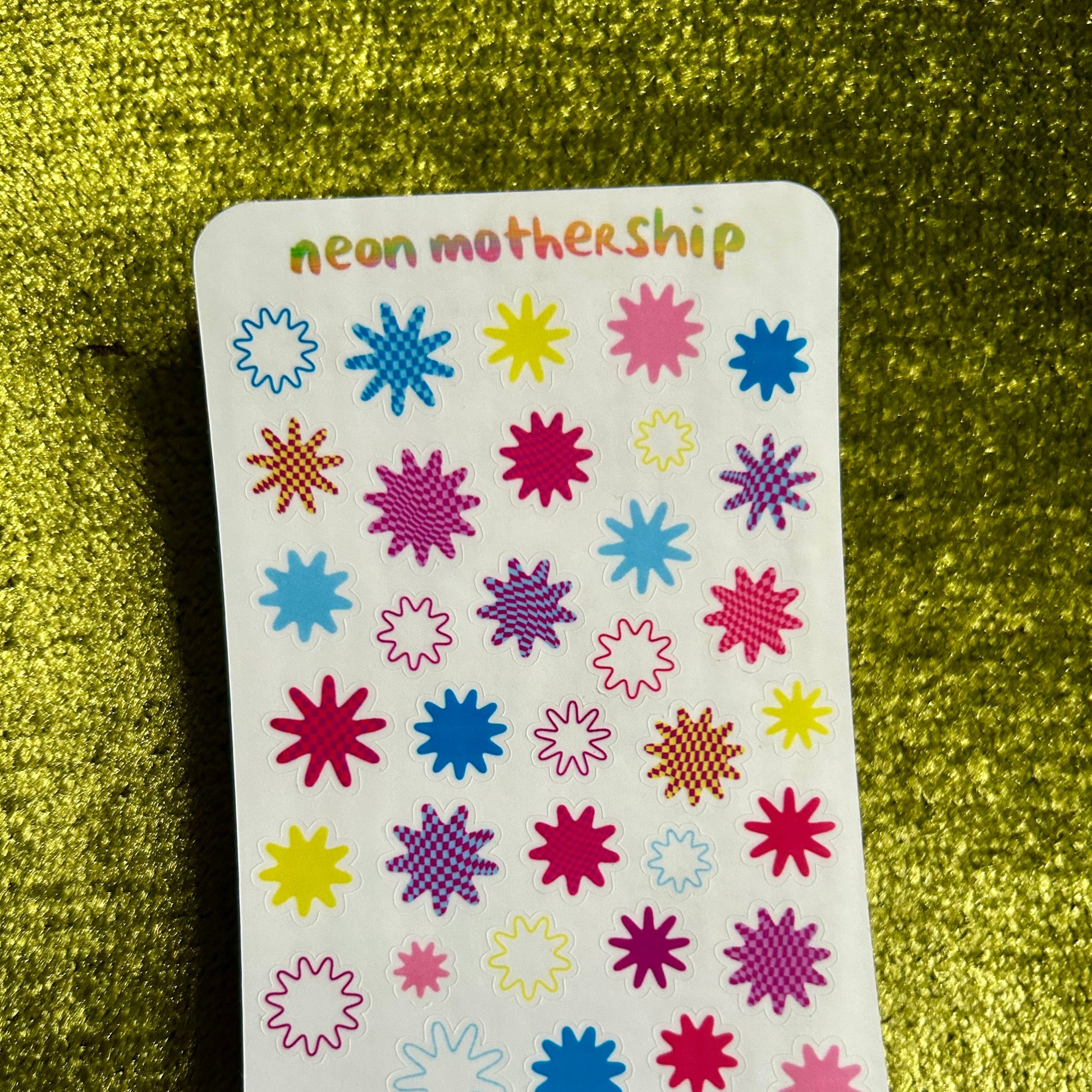 Card with colorful star-shaped stickers on a green textured background