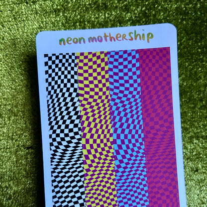 sticker sheet with checkered patterns and 'neon mothership' text on a green textured surface