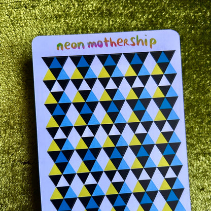 sticker sheet with geometric triangle pattern and 'neon mothership' text on a green textured background