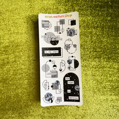 Sheet of stickers with various designs on a green textured surface