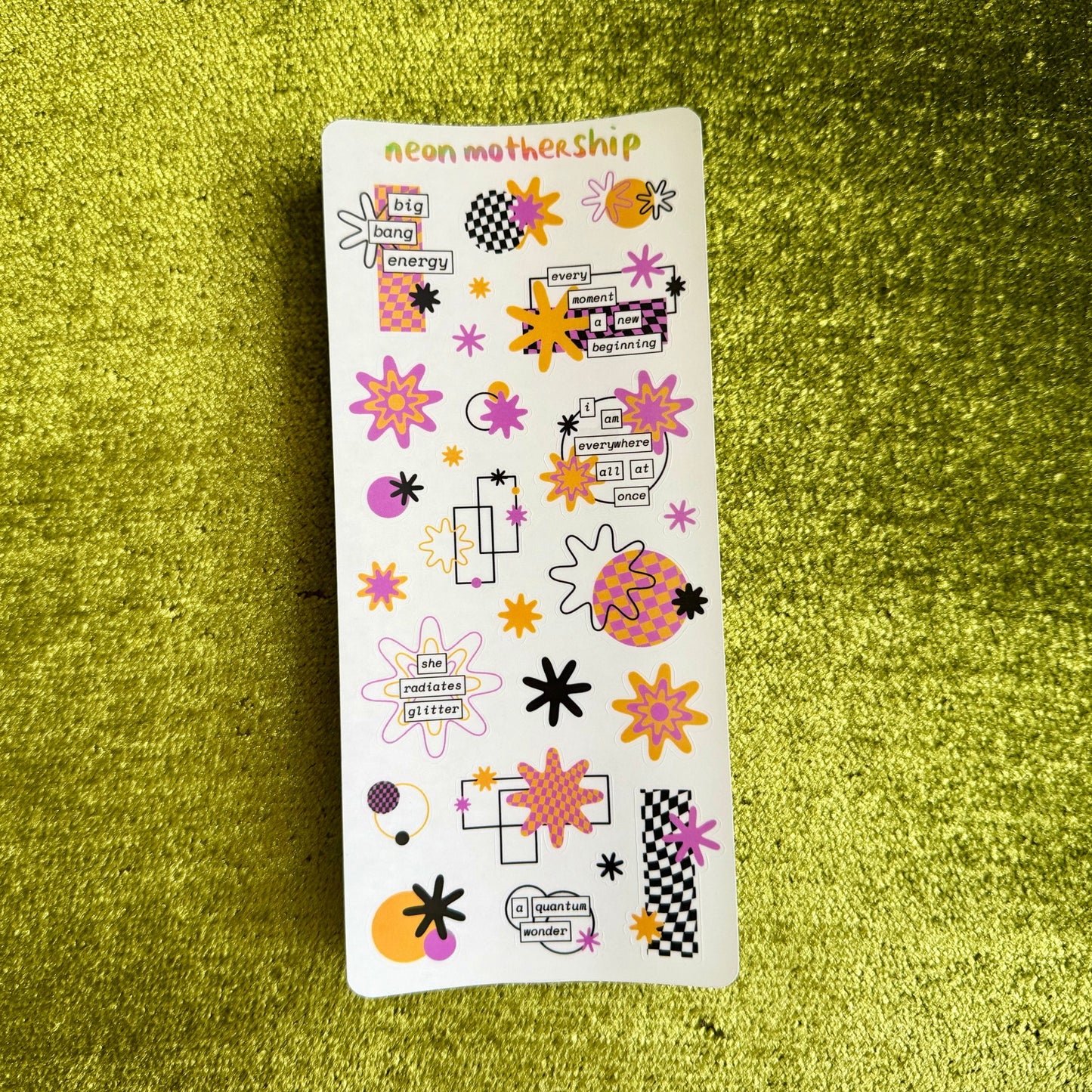Sheet of colorful stickers on a green textured surface