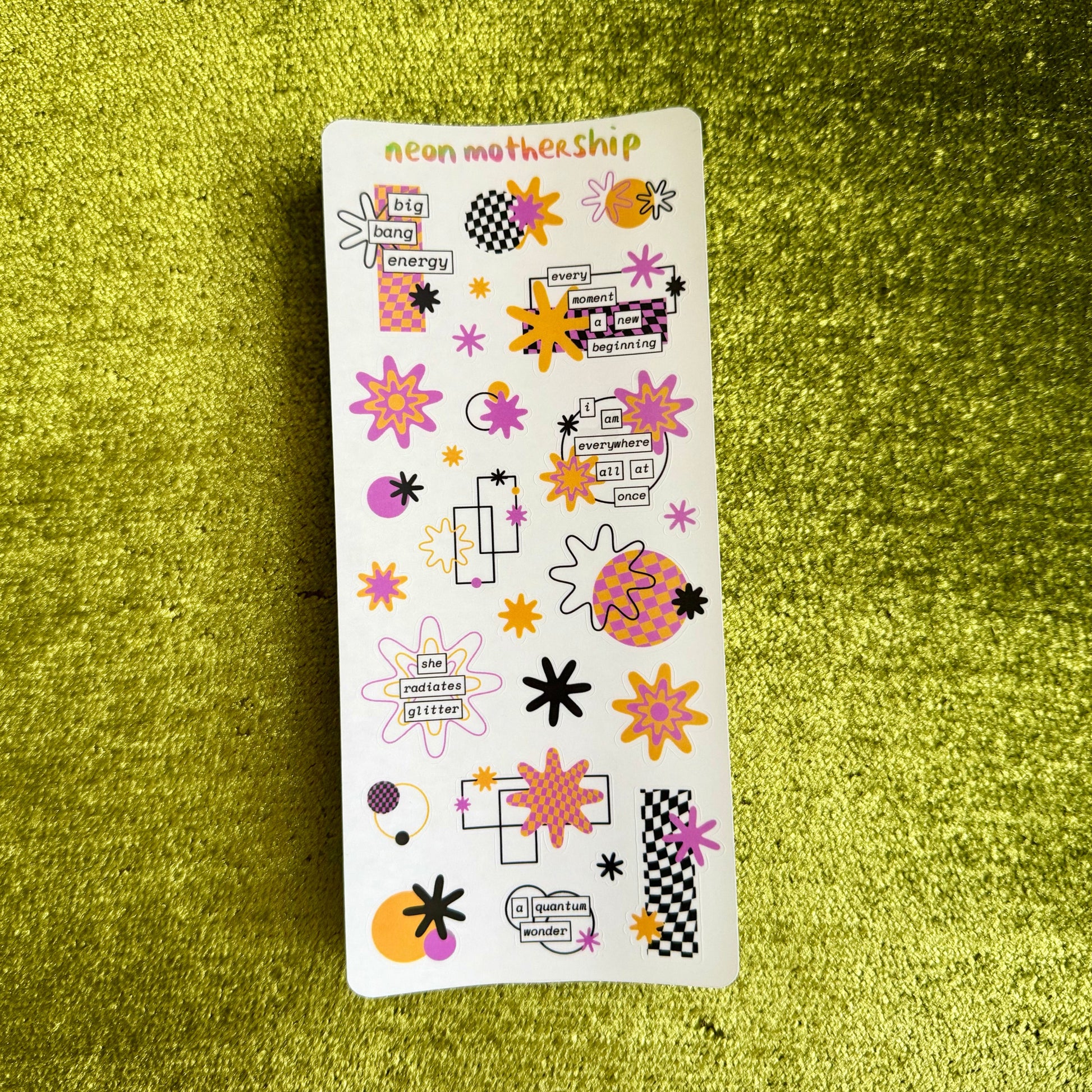 Sheet of colorful stickers on a green textured surface