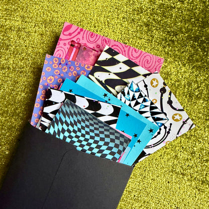 Colorful patterned papers on a green textured surface