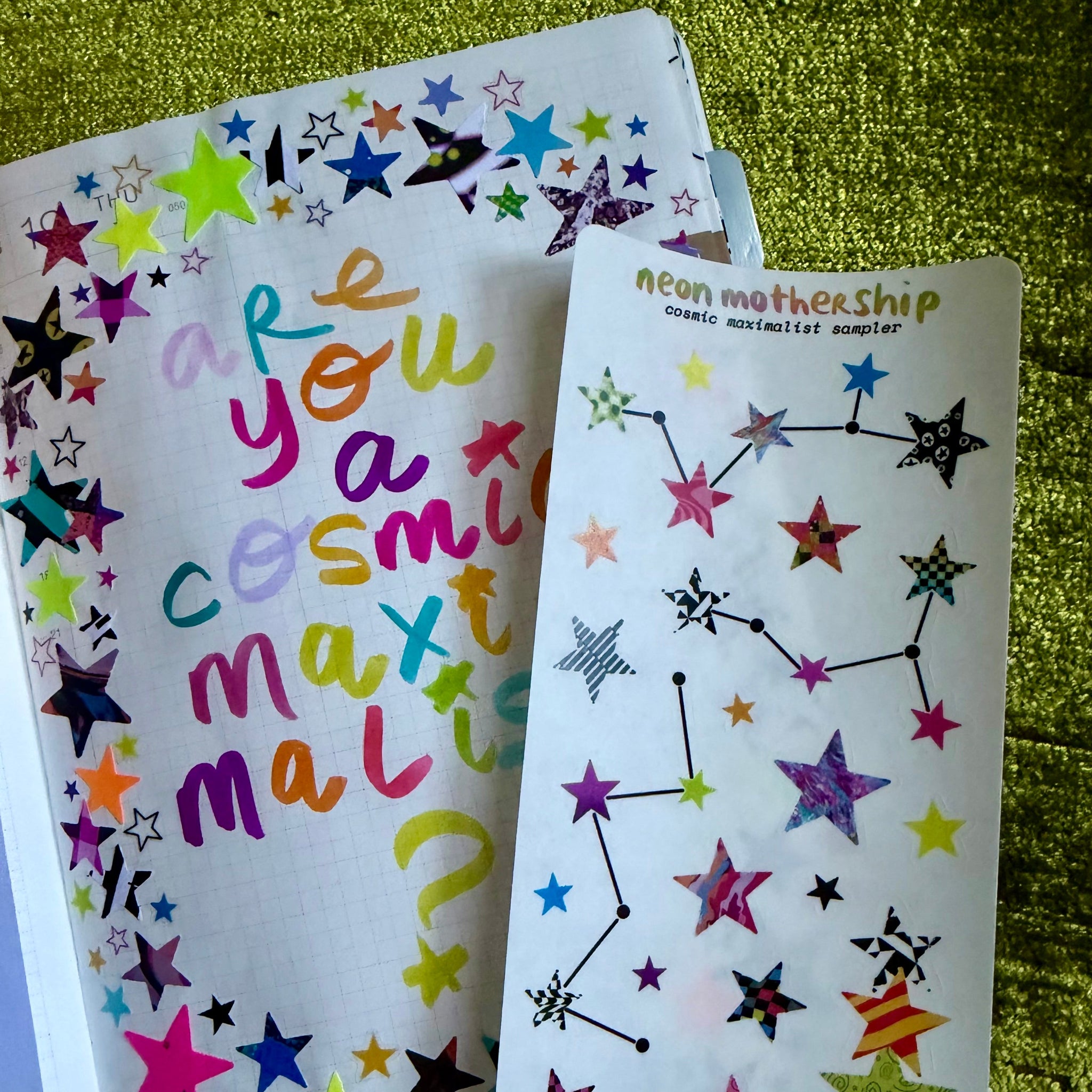 Colorful star-shaped stickers on a white sticker sheet with text on a green textured background