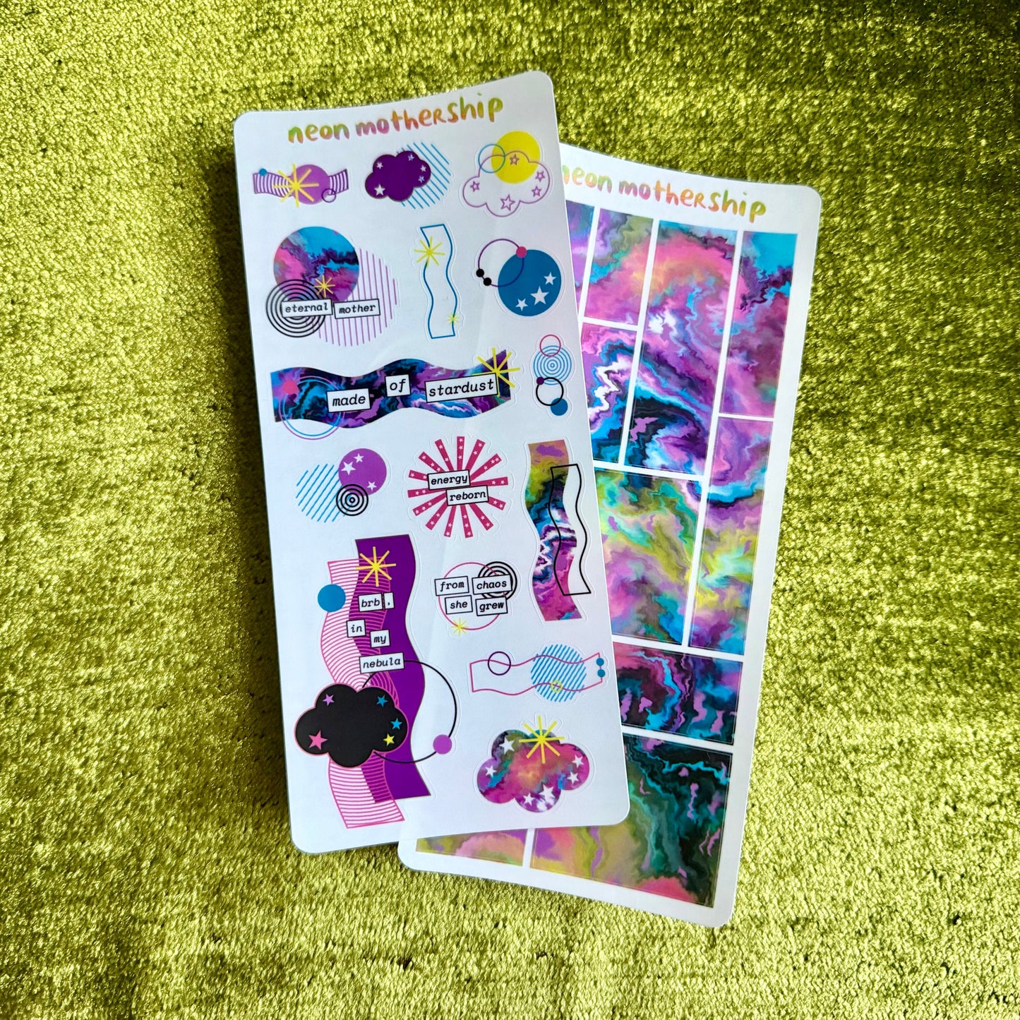 Colorful sticker sheets on a green textured surface