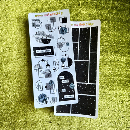 Two sheets of stickers with geometric designs on a green textured surface