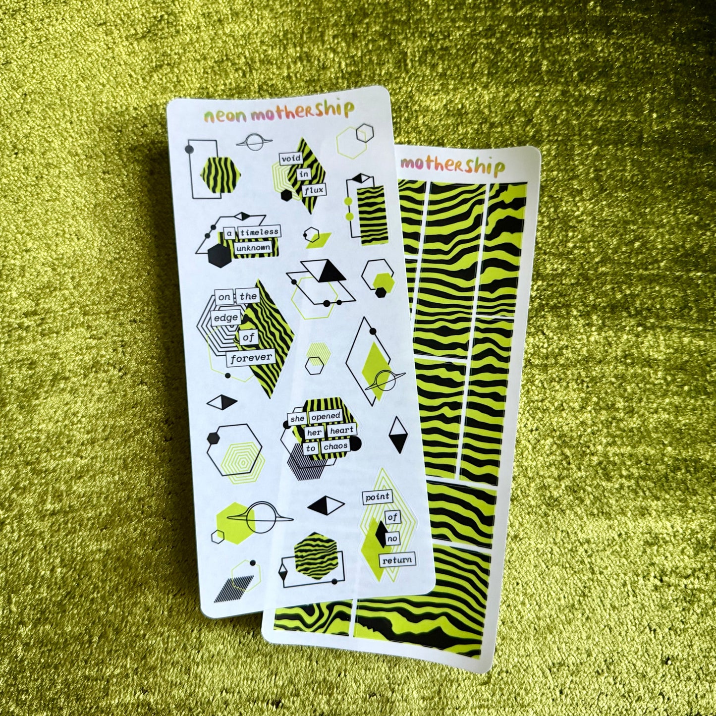 Two sheets of geometric patterned stickers on a green textured surface