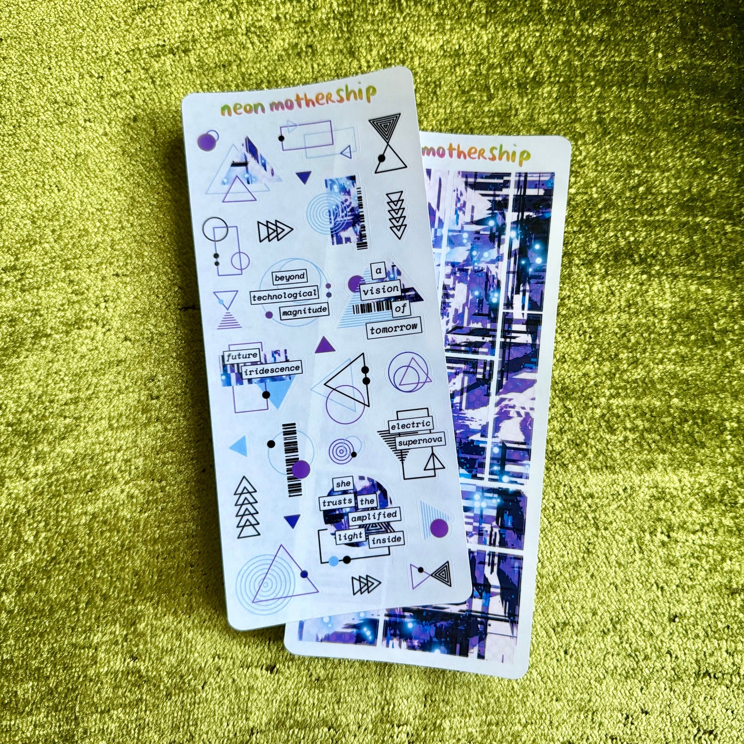 Two sticker sheets with geometric designs on a green textured surface