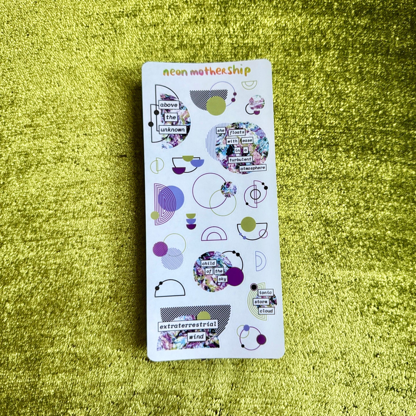 Pack of stickers with various designs on a green textured surface