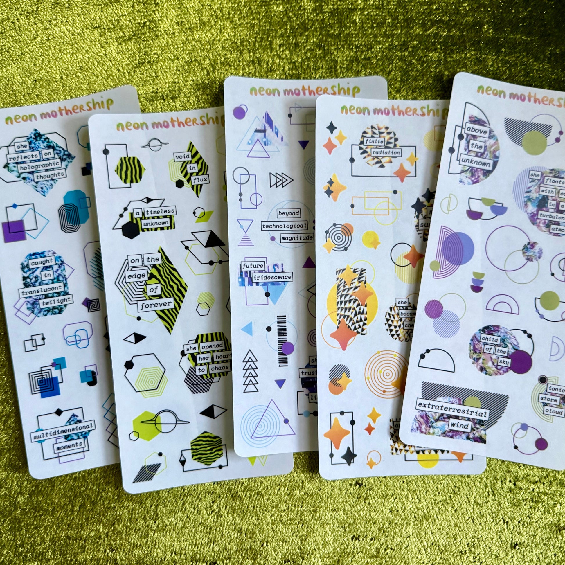 Five sheets of decorative stickers with geometric and abstract designs on a green textured surface.