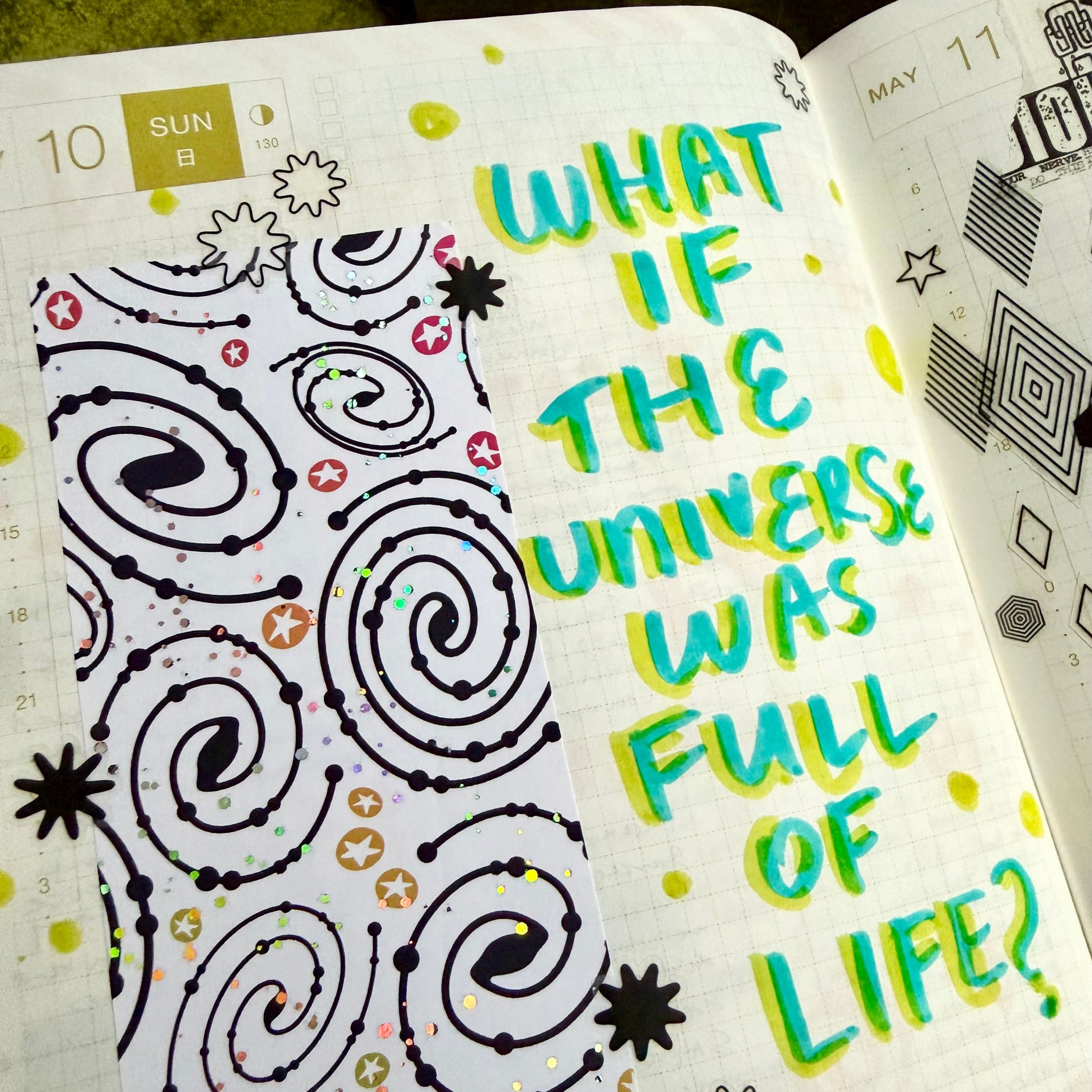 Open notebook with doodles and text 'What if the universe was full of life?'