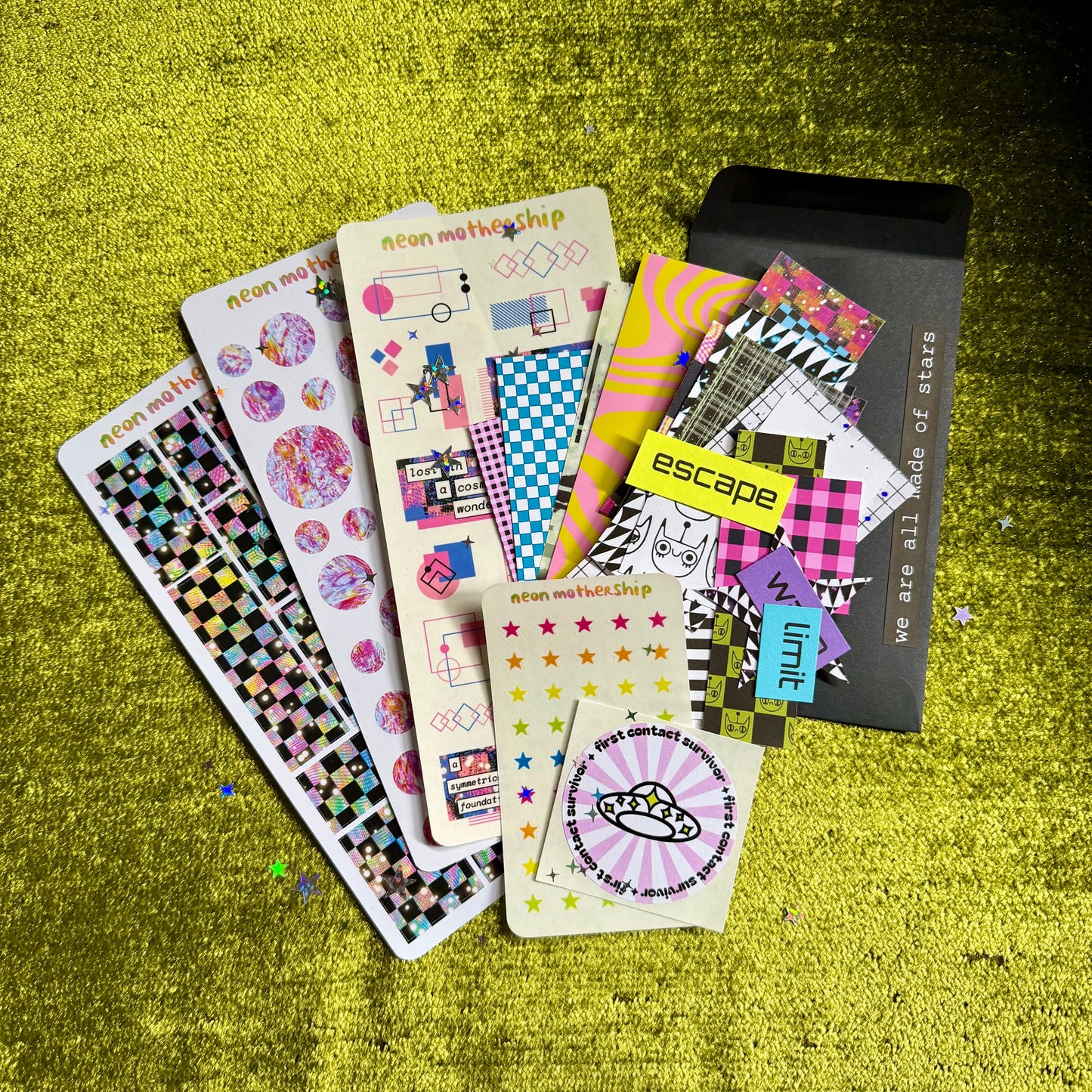 Collection of colorful stickers and papers on a textured green surface