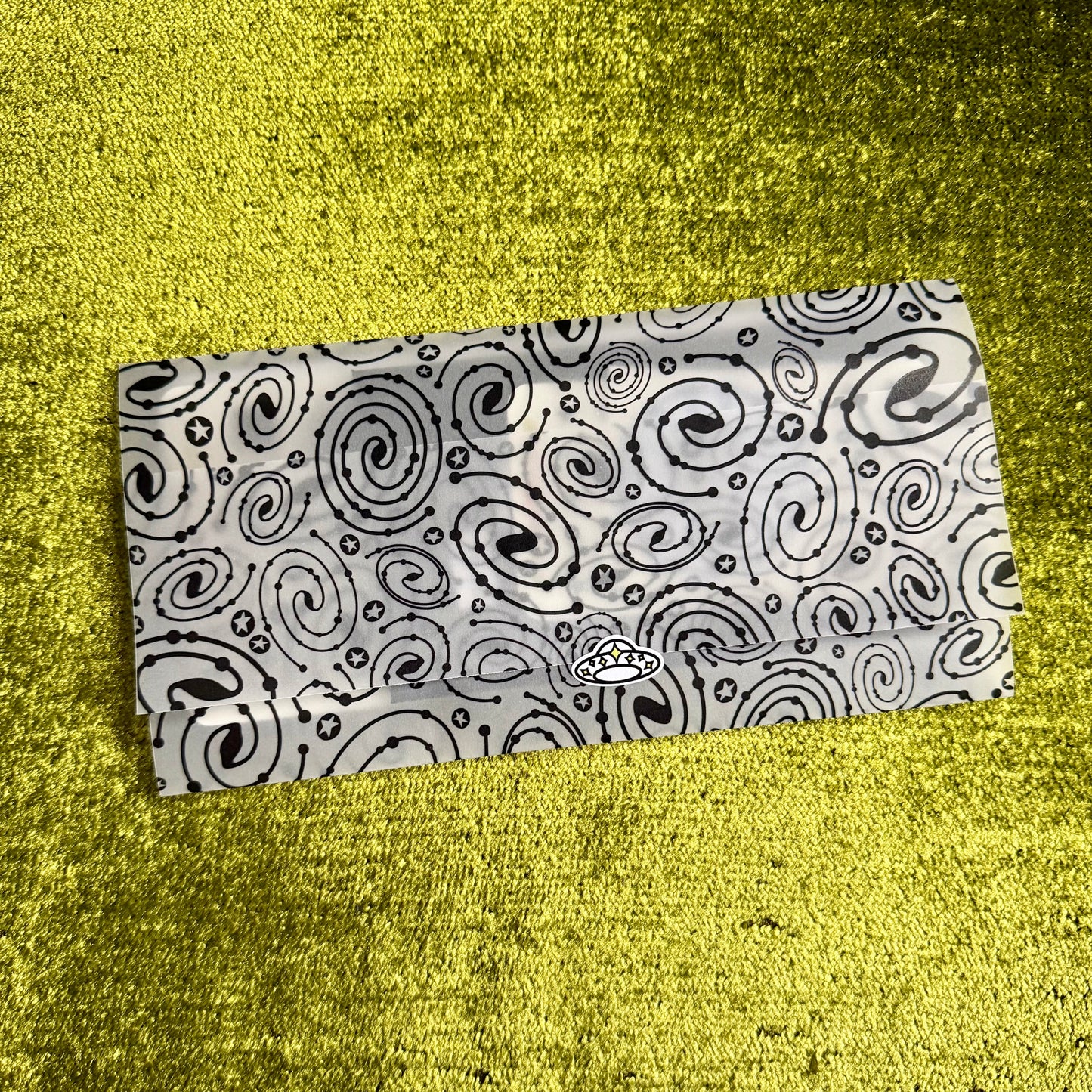 Black and white patterned vellum envelope on a yellow textured surface