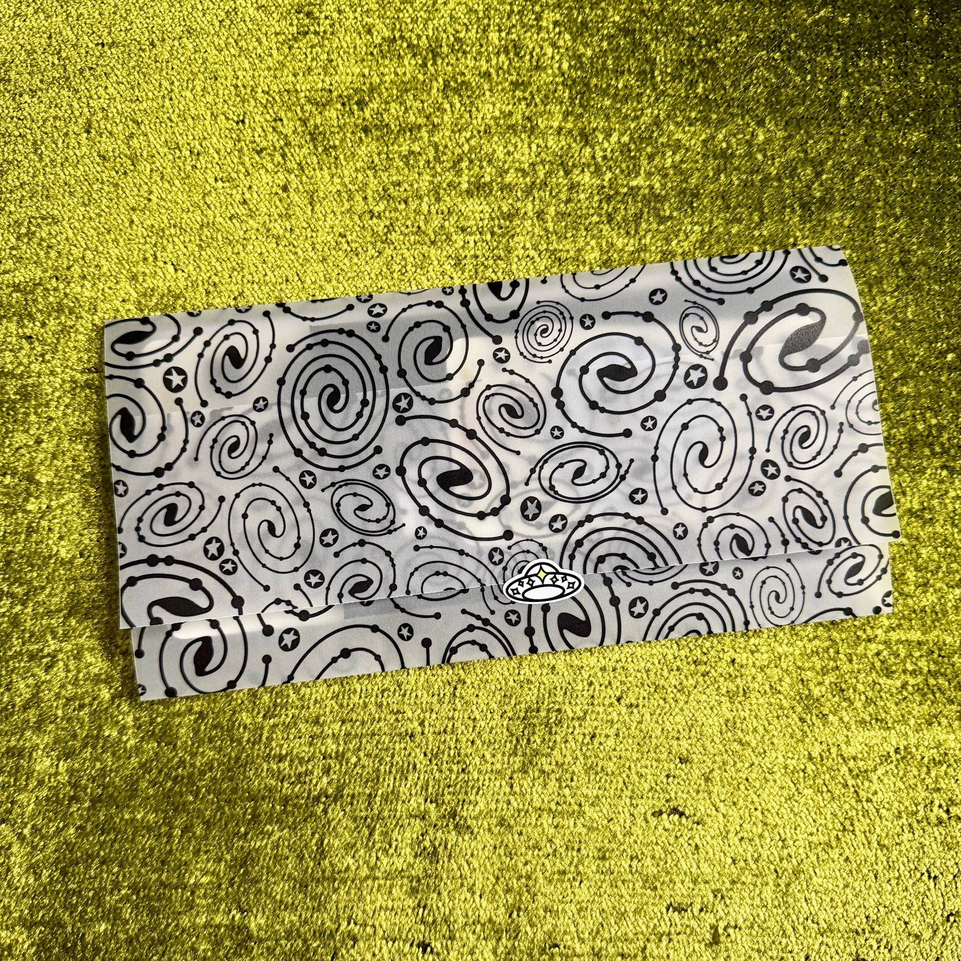 Black and white patterned vellum envelope on a yellow textured surface