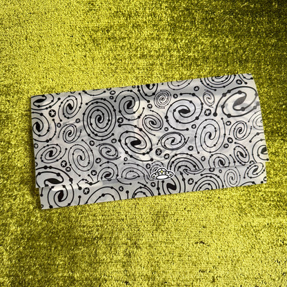 Black and white patterned vellum envelope on a yellow textured surface