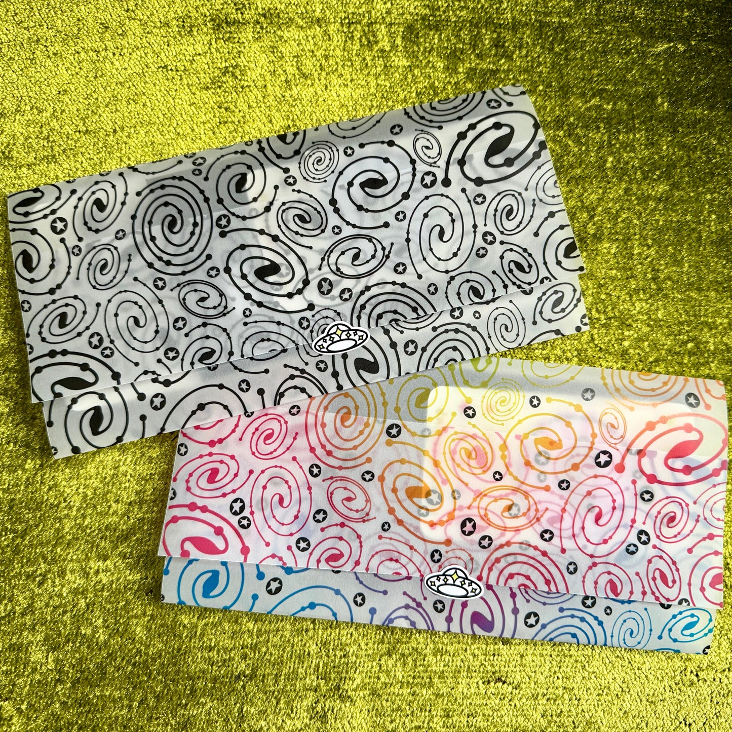 Two patterned vellum envelopes on a textured yellow surface