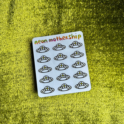 Sheet of stickers with black illustrations on a white card, labeled 'neon mothership', against a green textured background.
