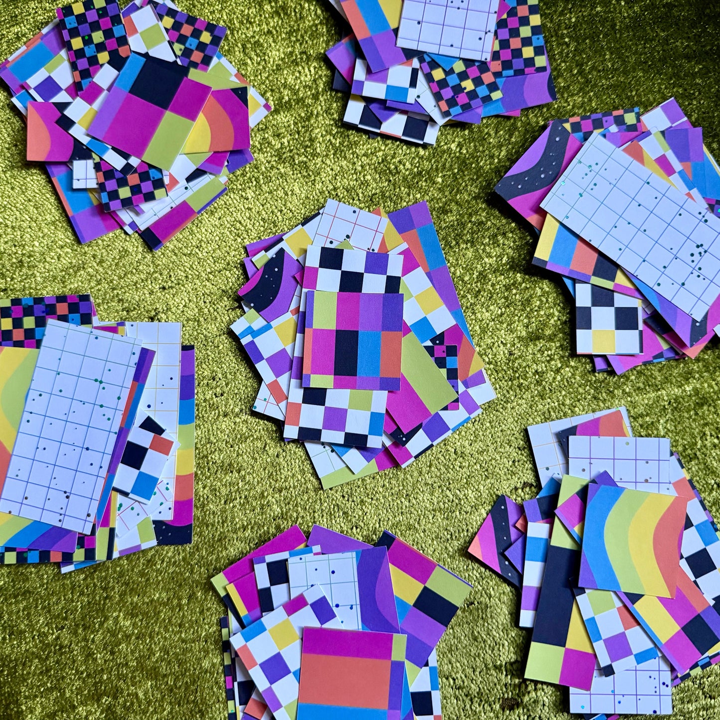 several stacks of colorful sticker paper scraps on a green background