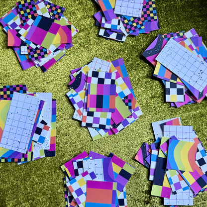 several stacks of colorful sticker paper scraps on a green background