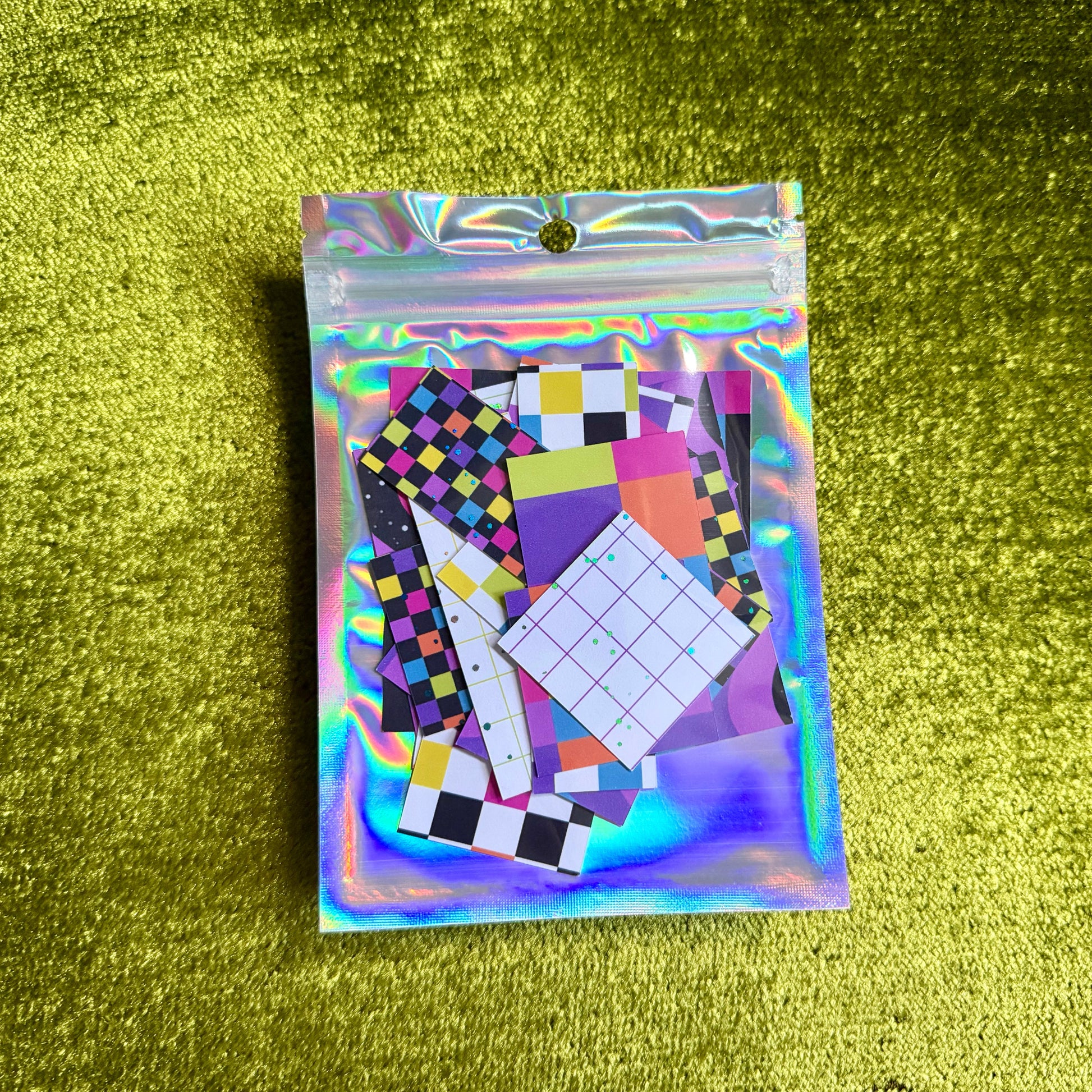 small package of colorful sticker scraps on a green background