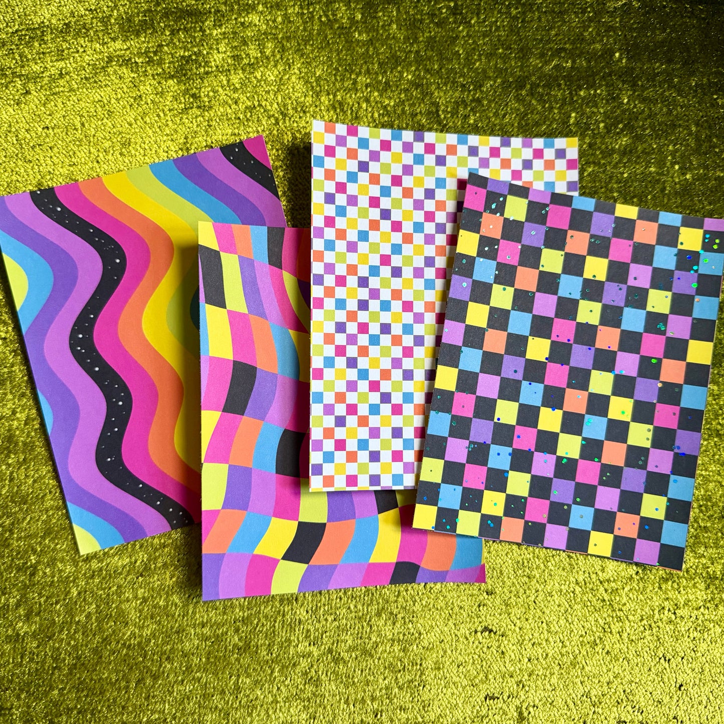 four colorful sticker sheets on a green background