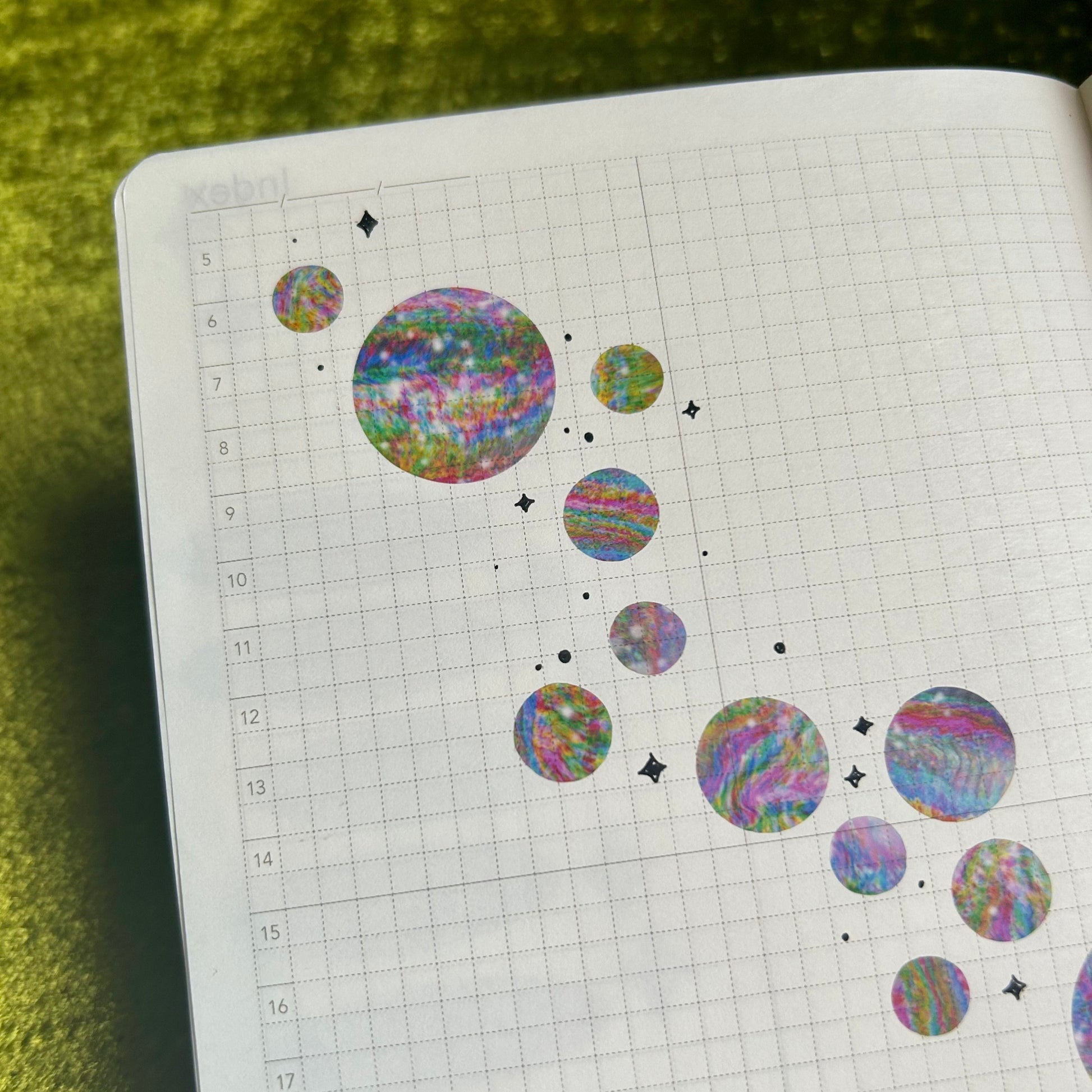 Notebook with colorful circular stickers on a chartreuse background