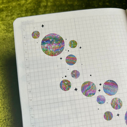 Notebook with colorful circular stickers on a chartreuse background
