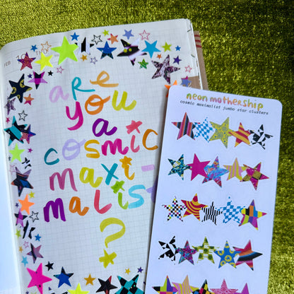Colorful star-themed notebook and sticker sheet on a green textured surface