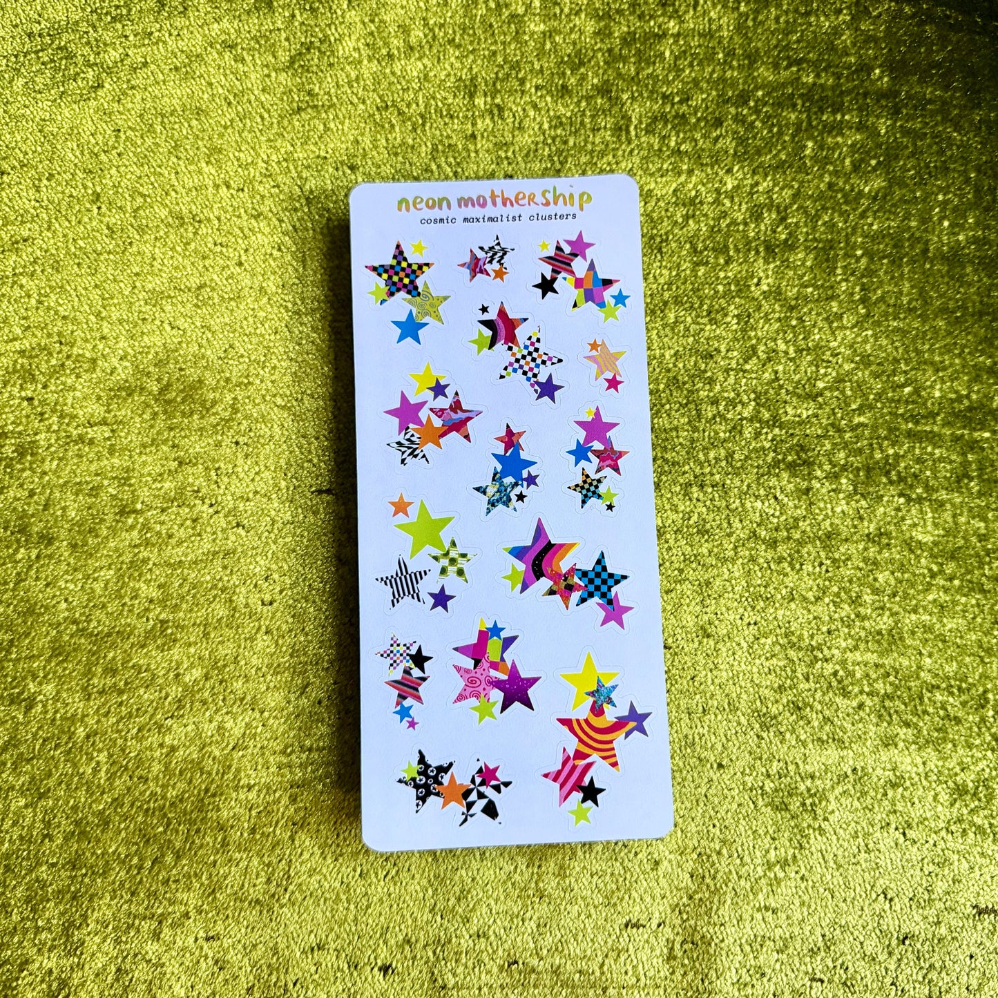 sticker sheet with colorful star-shaped stickers on a green textured surfac
