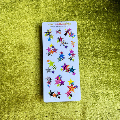 sticker sheet with colorful star-shaped stickers on a green textured surfac