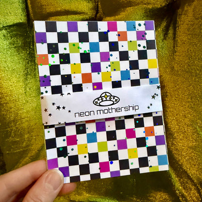 hand holding colorful sticker paper on a green background