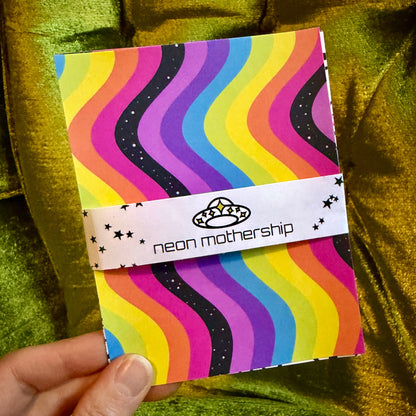hand holding colorful sticker paper on a green background